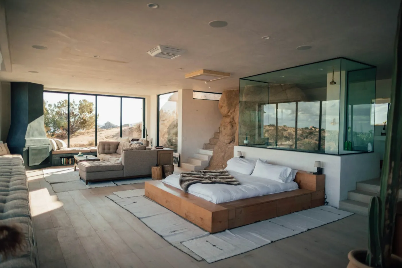 Suíte de hotel de luxo com paredes de vidro e vista para a paisagem